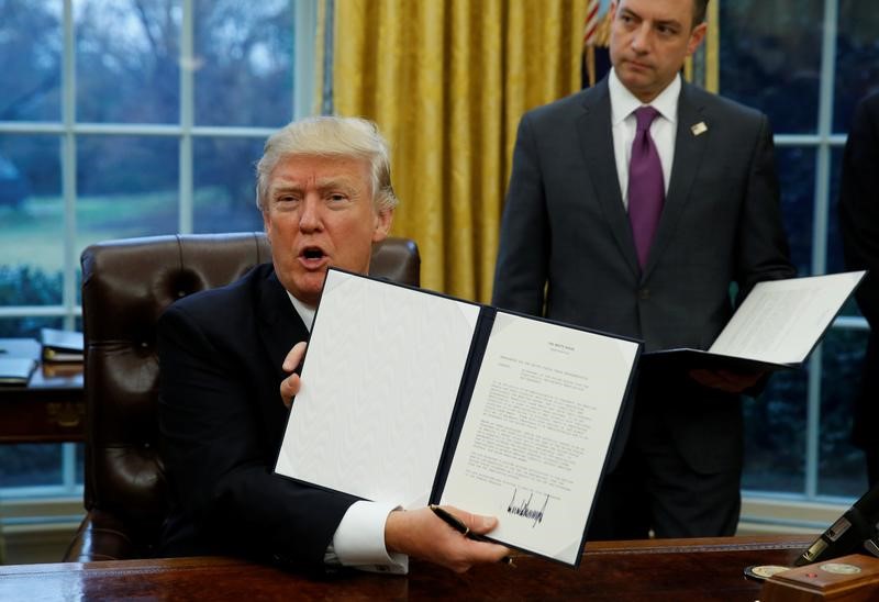 © Reuters. O presidente dos Estados Unidos, Donald Trump, mostra a ordem que formaliza a saída do acordo Transpacífico após assiná-la na Casa Branca, em Washington