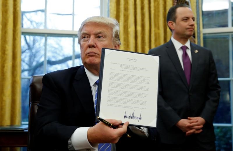 © Reuters. President Trump signs executive orders at the White House in Washington