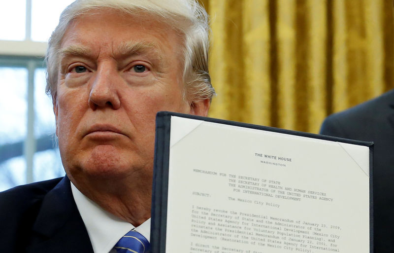 © Reuters. U.S. President Donald Trump holds up his executive order on the reinstatement of the Mexico City Policy after signing it in the Oval Office of the White House in Washington