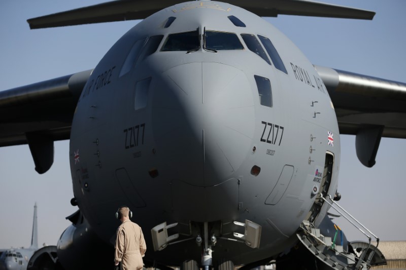 © Reuters. A British soldier stands in front of a Royal Airforce  C-17 Globemaster III aircraft at a Kandahar airfield, Afghanistan