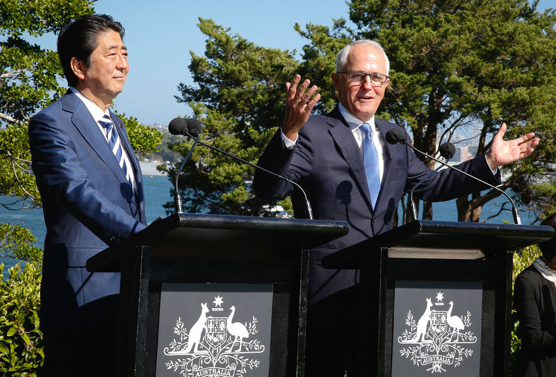 © Reuters. Japanese Prime Minister Shinzo Abe listens as Australian Prime Minister Malcolm Turnbull talks to members of the media after their bilateral meeting at Kirribilli House in Sydney, Australia