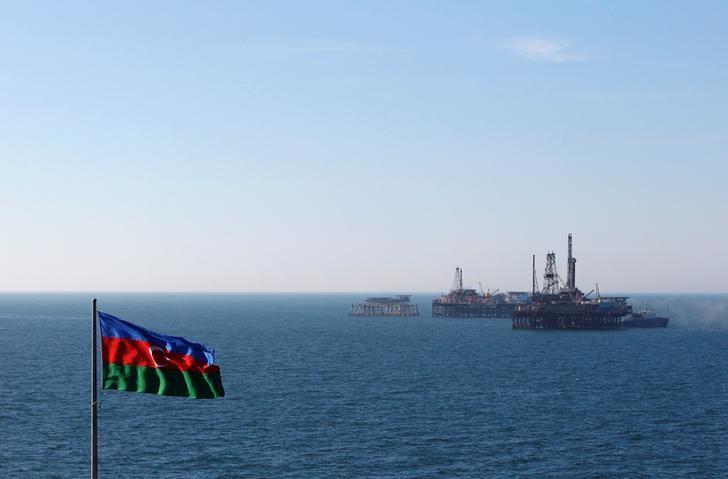 © Reuters. Флаг Азербайджана на фоне нефтяных платформ в Каспийском море