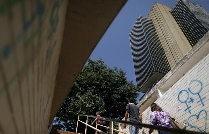 © Reuters. People walk outiside of the central bank headquarter building in Brasilia