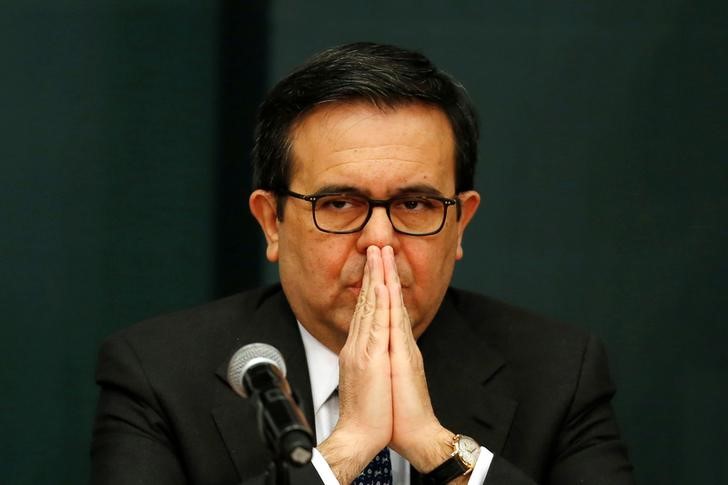 © Reuters. Mexico's Economy Secretary Ildefonso Guajardo Villarreal listens as Mexico's President Enrique Pena Nieto (unseen) announces a plan to strengthen the economics for families in Mexico City