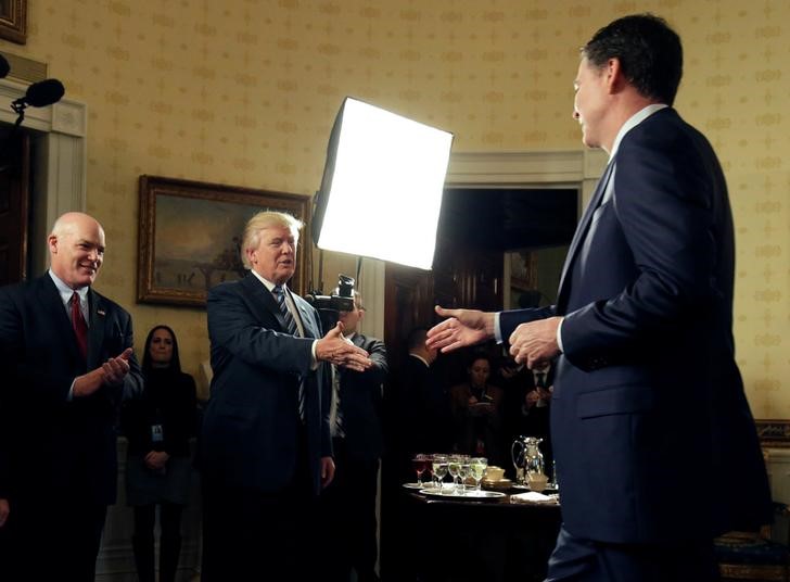 © Reuters. Donald Trump greets James Comey as Joseph Clancy watches during the Inaugural Law Enforcement Officers and First Responders Reception in the Blue Room of the White House in Washington