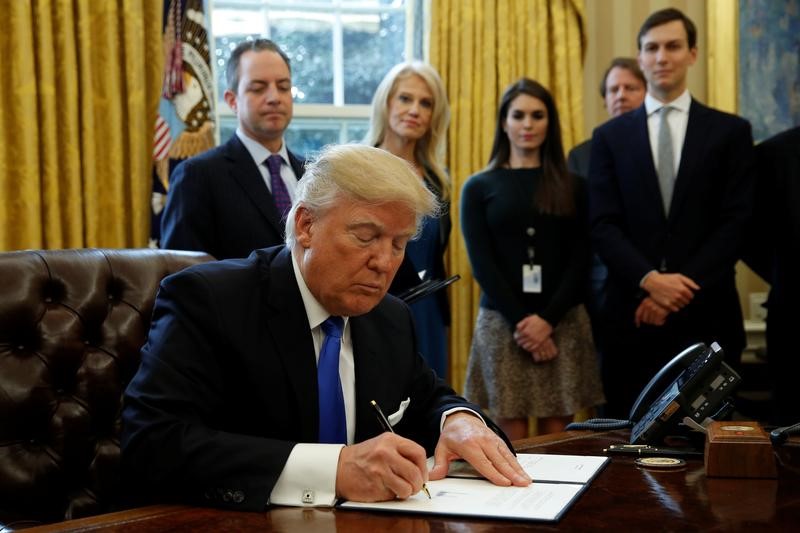 © Reuters. President Trump signs executive orders at the White House in Washington