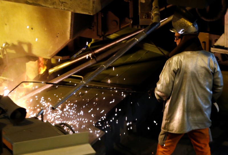 © Reuters. A worker uses a cutting torch near a reheating furnace at the ArcelorMittal steel plant in Ghent