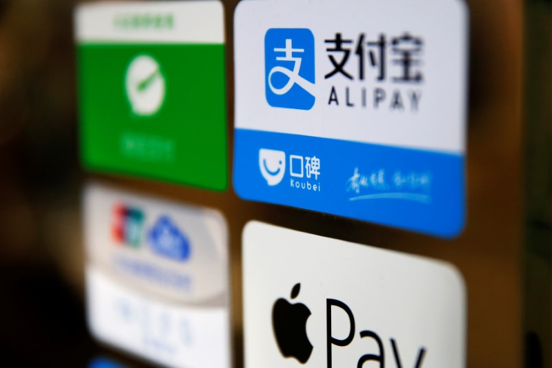 © Reuters. An Alipay logo is seen among other paying method stickers on the doors of a restaurant at the Beijing Railway Station in central Beijing