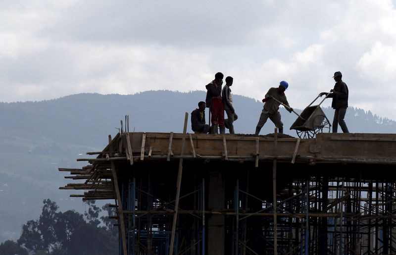 © Reuters. FILE PHOTO: Construction workers work on the roof of a new building at the Mercato market in Addis Ababa