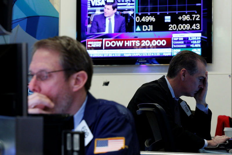 © Reuters. Traders work on the floor of the NYSE as the Dow Jones Industrial Average passes the 20,000 mark in New York