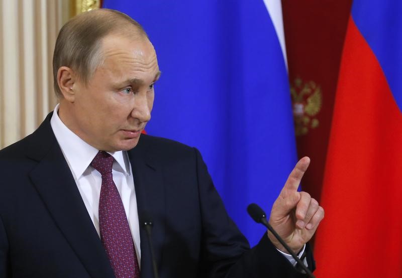 © Reuters. بوتين يغني خلال زيارة لجامعة موسكو