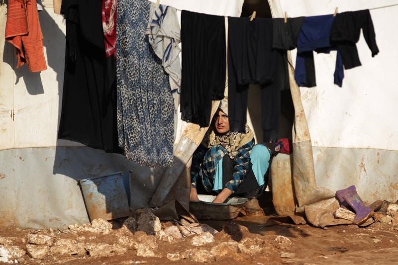 © Reuters. An internally displaced Syrian woman washes clothes inside her tent at the Bab Al-Salam refugee camp, near the Syrian-Turkish border