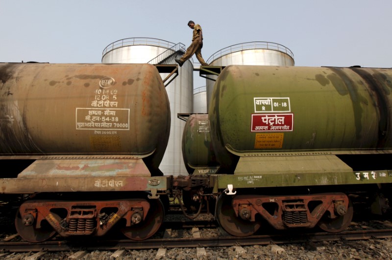 © Reuters. FILE PHOTO:  A worker walks atop a tanker wagon to check the freight level at an oil terminal on outskirts of Kolkata