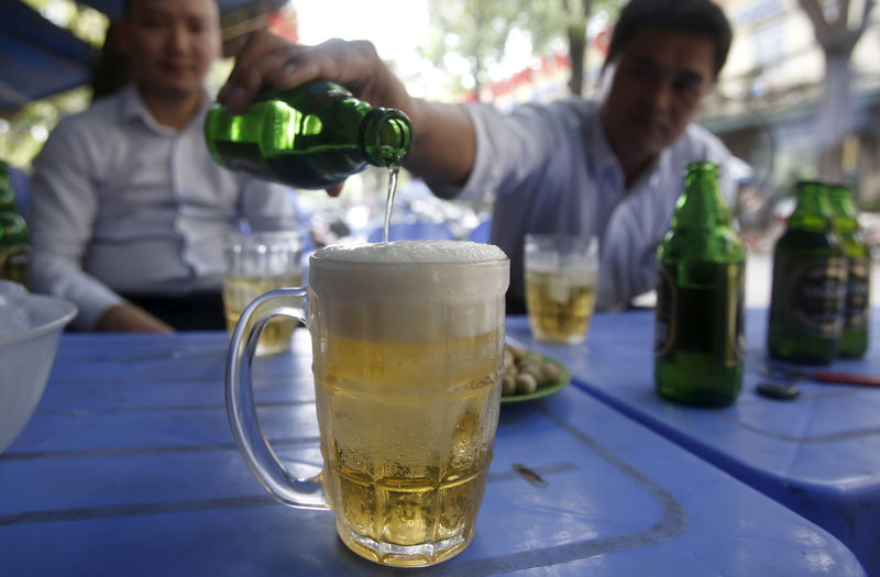 © Reuters. FILE PHOTO -  A man pours Saigon beers into a cup at a restaurant in Hanoi, Vietnam