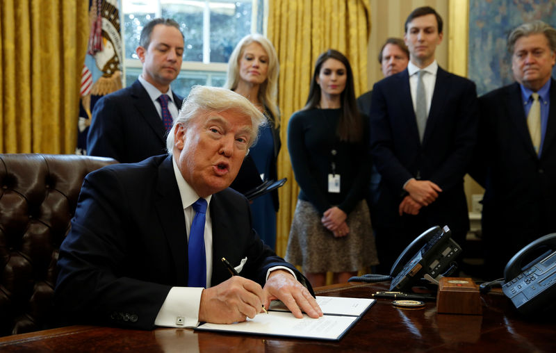 © Reuters. President Trump signs executive orders at the White House in Washington