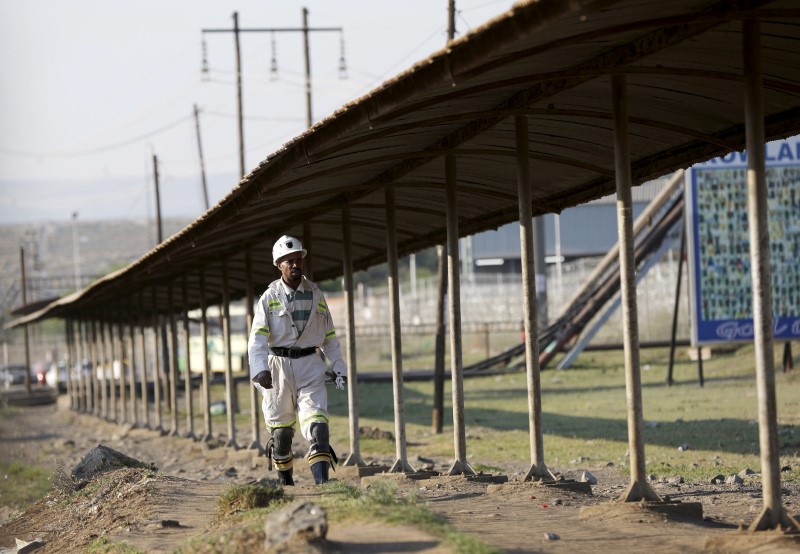 © Reuters. A mine worker returns from the Lonmin mine at the end of his shift, outside Rustenburg