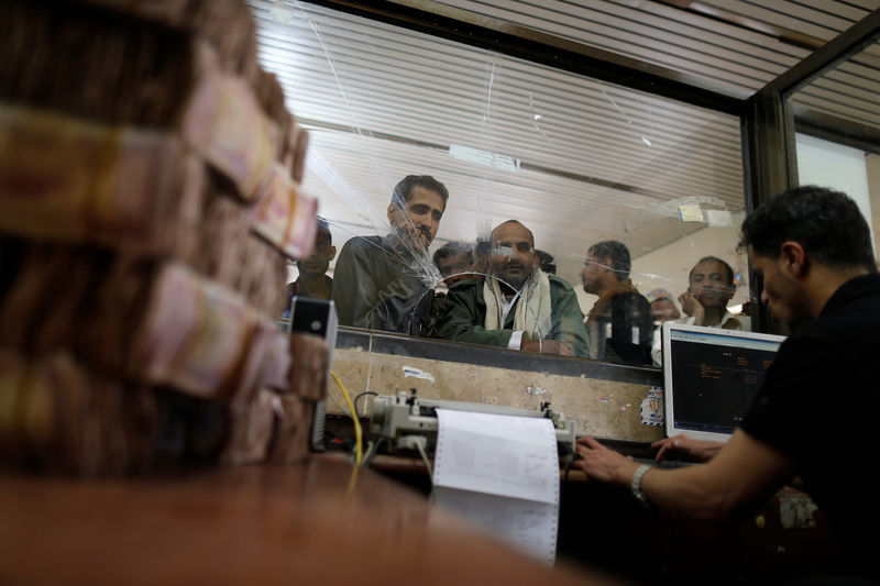 © Reuters. Public sector employees crowd at a post office to receive their salaries in Sanaa