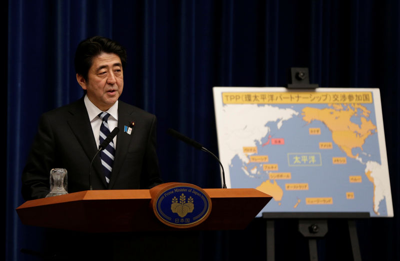 © Reuters. FILE PHOTO -  Japan's Prime Minister Shinzo Abe speaks next to a map showing participating countries in rule-making negotiations for the TPP during a news conference in Tokyo