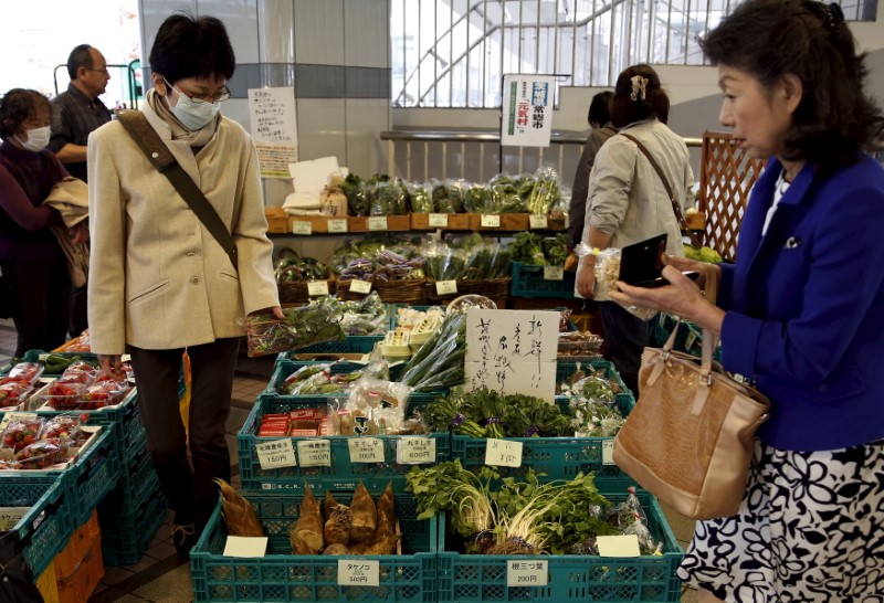 © Reuters. Shoppers look at vegetables at a greengrocer at Ginza shopping district in Tokyo