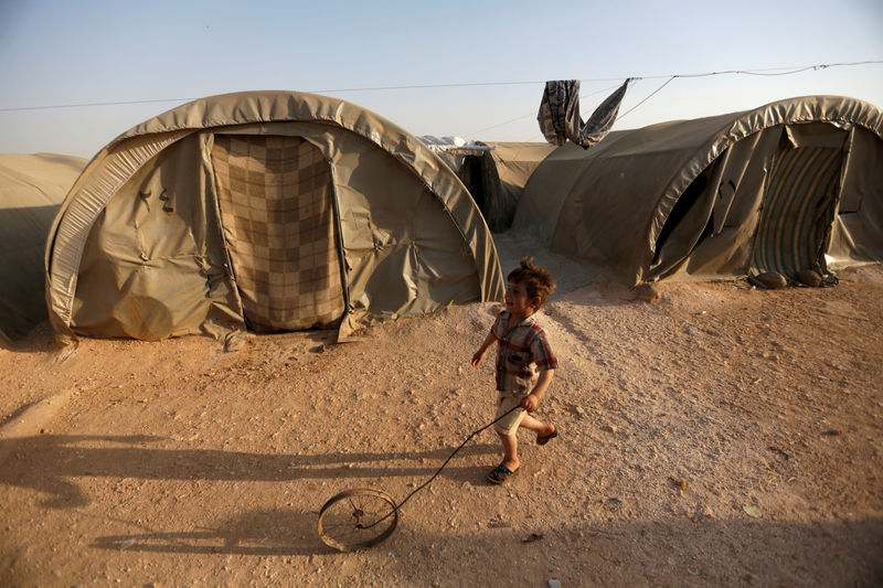 © Reuters. FILE PHOTO: An internally displaced Syrian boy plays with a wheel in Jrzinaz camp