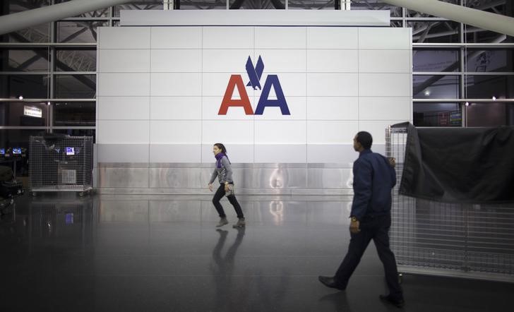 © Reuters. People walk past an American Airlines logo at John F. Kennedy (JFK) airport in in New York