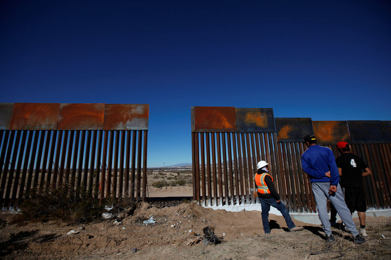 © Reuters. Worker chats with residents at a newly built section of the U.S.-Mexico border fence at Sunland Park, U.S. opposite the Mexican border city of Ciudad Juarez