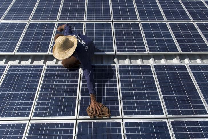 © Reuters. Homem limpa painéis solares que fornecem energia para máquina de fazer gelo na comunidade de Vila Nova do Amana, no Amazonas