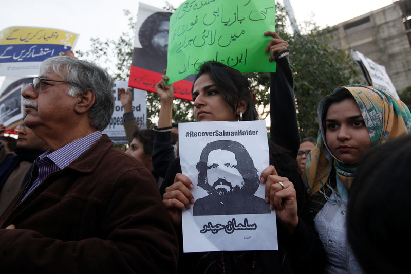 © Reuters. Human rights activists hold a picture of Salman Haider, who is missing, during a protest to condemn the disappearances of social activists in Karachi