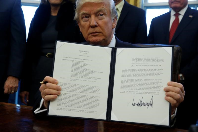 © Reuters. Trump signs a memorandum to security services directing them to defeat the Islamic State in the Oval Office at the White House in Washington