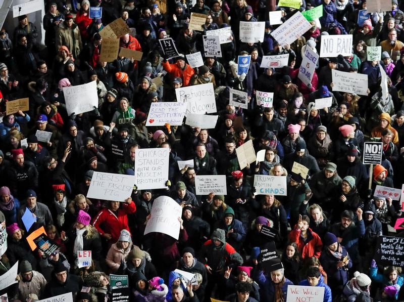 © Reuters. Gente reunida en el aeropuerto internacional O'Hare de Chicago protesta contra prohibiciones a los viajes decretadas por el presidente de Estados Unidos, Donald Trump.