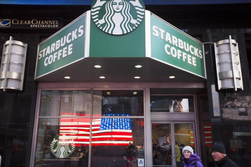 © Reuters. Pedestrians walk past a Starbucks store in the Manhattan borough of New York