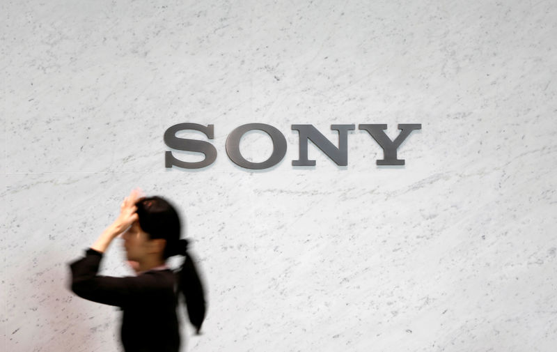 © Reuters. FILE PHOTO -  A reception staff walks under a logo of Sony Corp at its headquarters in Tokyo