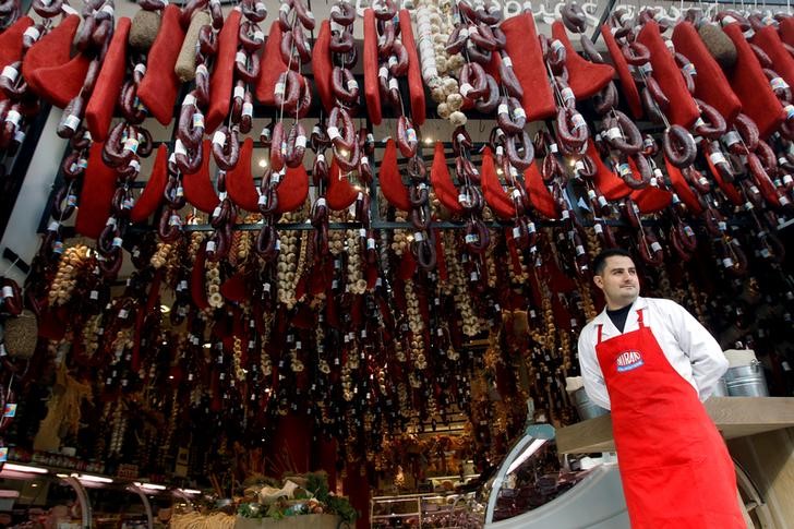 © Reuters. A grocer stands outside his shop in Athens