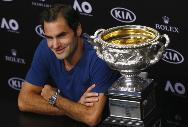 © Reuters. El tenista suizo Roger Federer participa en una conferencia de prensa junto a su trofeo tras ganar al Abierto de Australia