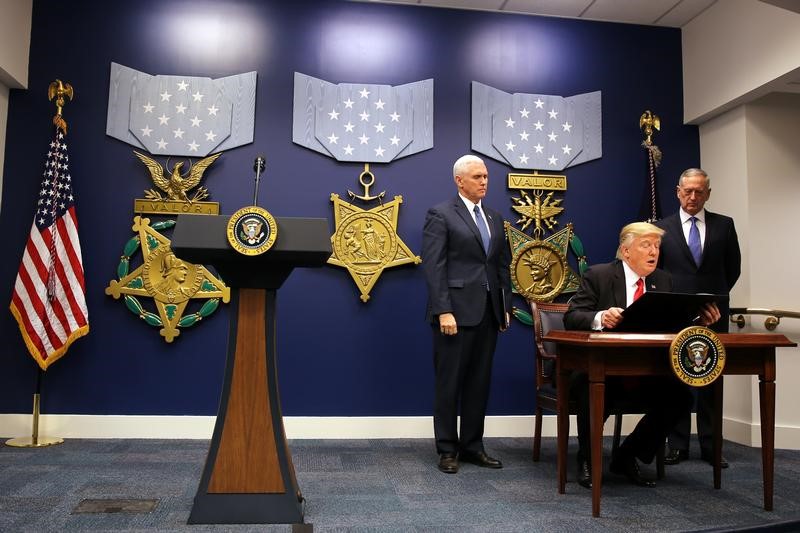 © Reuters. U.S. President Donald Trump signs an executive order to impose tighter vetting of travelers entering the United States, at the Pentagon in Washington