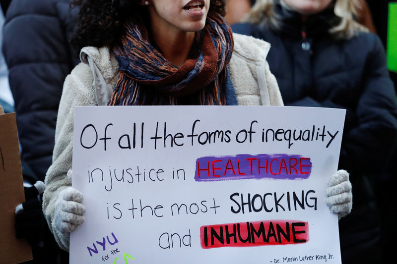 © Reuters. A demonstrator holds a sign while taking part in a protest against a proposed repeal of the Affordable Care Act in New York