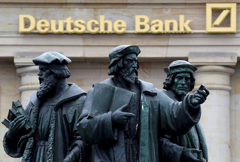 © Reuters. FILE PHOTO -  A statue is pictured next to the logo of Germany's Deutsche Bank in Frankfurt