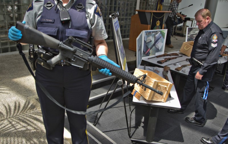 © Reuters. A member of Royal Canadian Mounted Police holds an assault rifle that was turned in to the police in Richmond