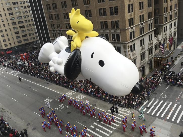 © Reuters. A float depicting the animated "Peanuts" characters Snoopy and Woodstock proceeds along 6th Ave as spectators watch from buildings during the 89th Macy's Thanksgiving Day Parade in the Manhattan borough of New York