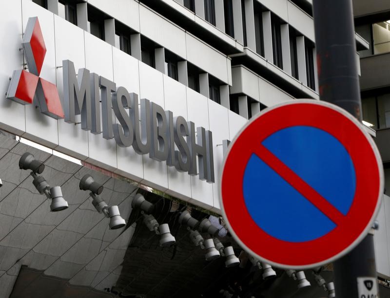 © Reuters. The company logo of Mitsubishi Motors is seen behind a traffic sign at its headquarters in Tokyo,