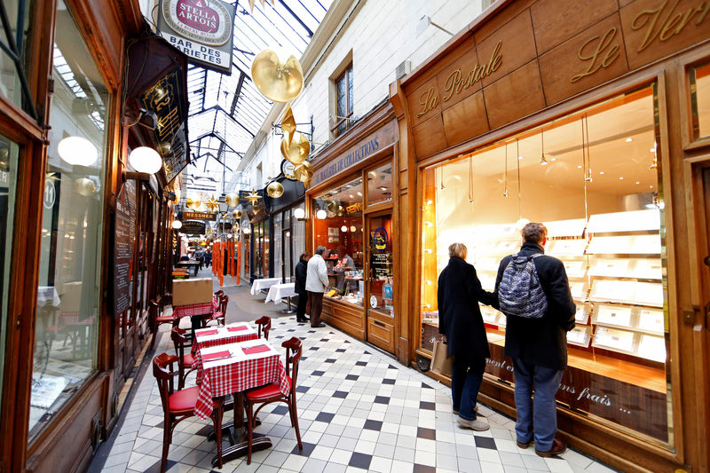 © Reuters. FILE PHOTO -  Visitors walk in the Passage des Panoramas, the oldest of the covered passages built in 1799 and housing bars and restaurants, old postcard shops and philatelist boutiques, in Paris