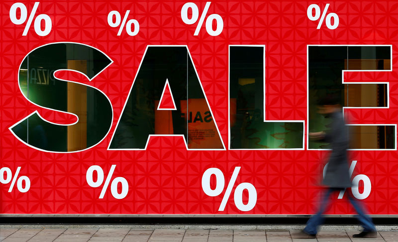 © Reuters. FILE PHOTO: A man passes a sign advertising the first day of winter sale shopping in Vienna