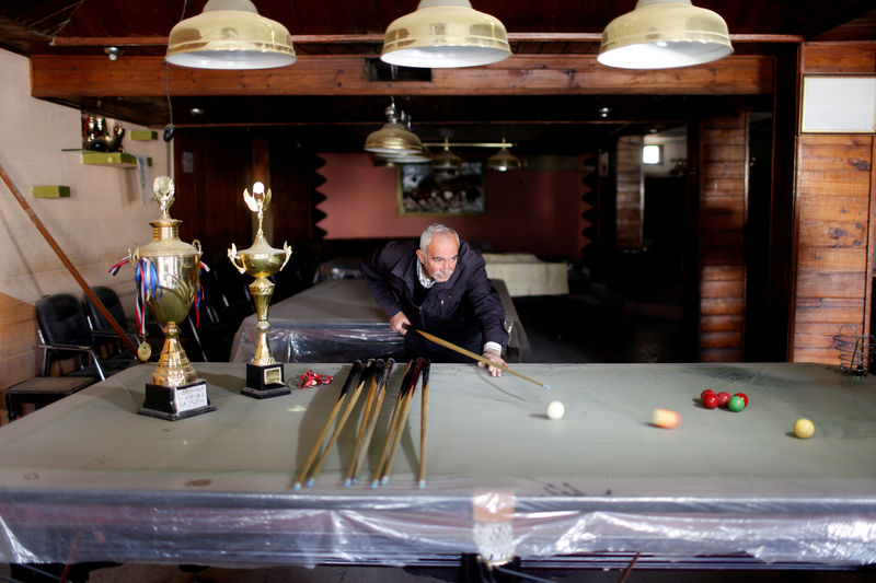 © Reuters. Billiard hall owner Jammal plays on a covered billiard table in the city of Mosul