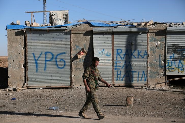 © Reuters. A Syrian Democratic Forces (SDF) fighter walks in Tal Samin village, north of Raqqa city