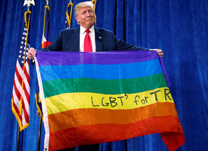 © Reuters. Republican presidential nominee Donald Trump holds up a rainbow flag with "LGBTs for TRUMP" written on it at a campaign rally in Greeley