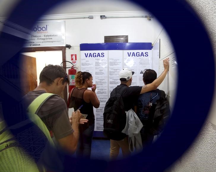 © Reuters. Pessoas olham para listas de vagas de trabalho em agência de empregos no centro de São Paulo