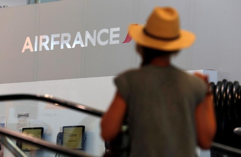 © Reuters. A passenger walks past an Air France logo at the Marseille-Provence airport in Marignane on the first day of a strike by Air France stewards