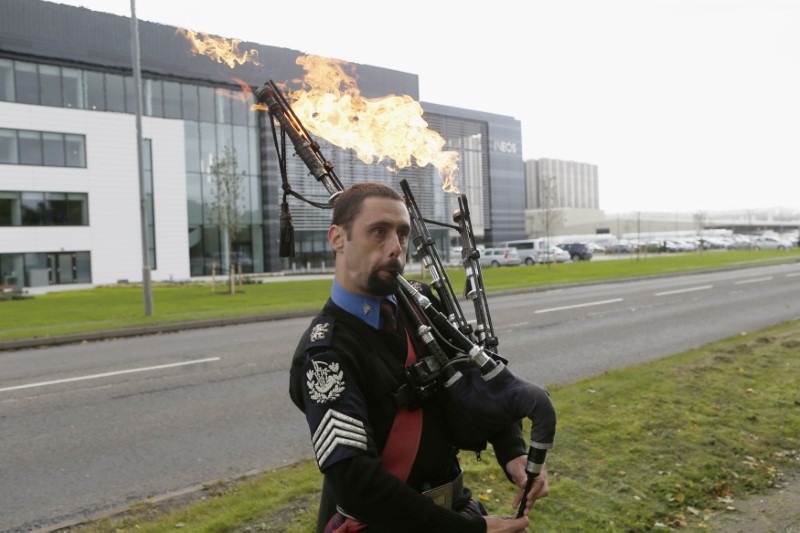 © Reuters. A man plays flaming bag pipes as opponents of fracking protest outside the offices of Ineos after they received the first shipment of shale gas to be delivered to the Britain at their Grangemouth  terminal in Scotland