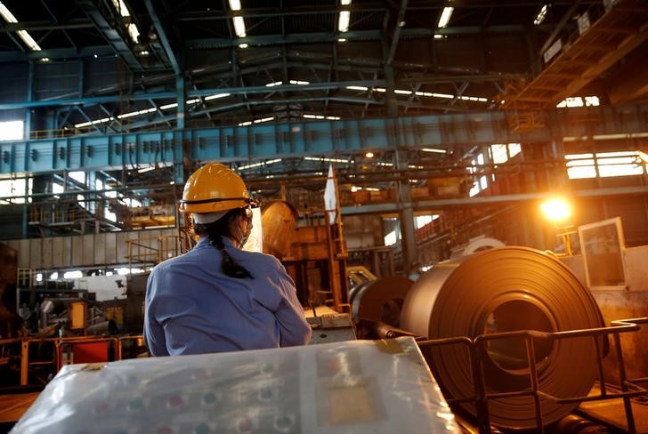 © Reuters. A worker moves a roll of steel using a remote control inside the China Steel Corporation factory in Kaohsiung