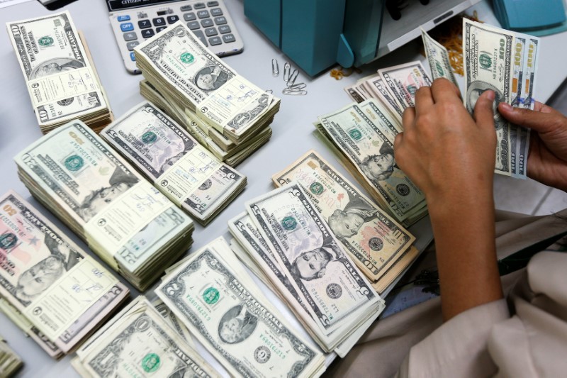 © Reuters. A bank employee counts U.S. dollar notes at a Kasikornbank in Bangkok